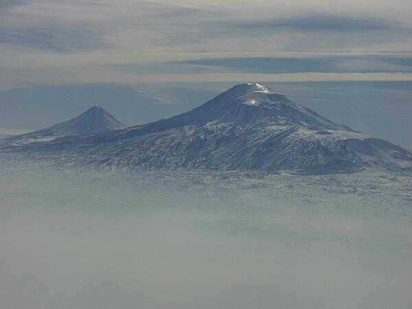 A view of Mount Ararat in western Turkey through the fog. The highest of its two peaks, Greater Ararat, is the tallest mountain in Turkey at 5,166 m (16,949 ft). Although located some 32 km (20 mi) from the Armenian border, the dormant volcano dominates the skyline of Yerevan, Armenia&apos;s capital. This photo was snapped after take off from the Yerevan airport.