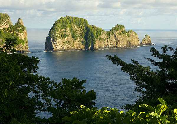 This view is a classic example of steep cliffs and erosion-resistant outliers formed by wave action on a volcanic land mass. Pola island rises over 125 m (400 ft) straight out of the ocean off Tutuila. A short walk from Vatia village, Pola is an ideal nesting site for many species of seabirds. Photo courtesy of the US National Park Service.