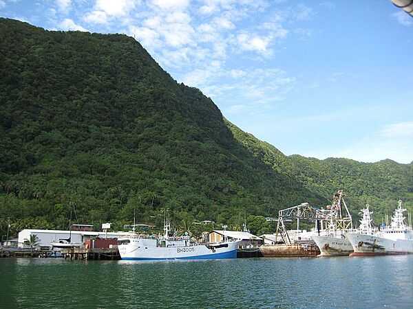 The tall mountains surrounding Pago Pago make it a sheltered harbor. Shown here are tuna boats in port. Photo courtesy of NOAA.