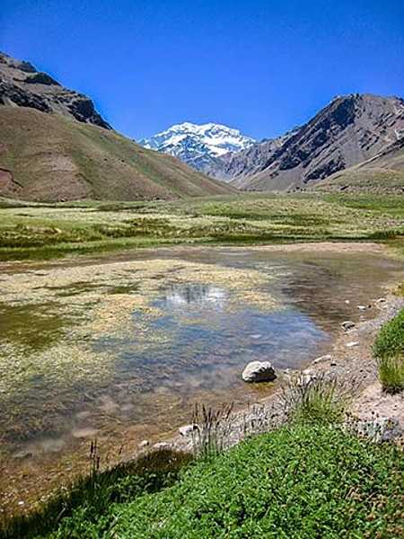 A view of Laguna de Horcones at 2,950 m in Parque Provincial Aconcagua, Mendoza, Argentina. Snow covered Aconcagua, the largest mountain in the Western Hemisphere at 6,962 m, stands prominently in the background.