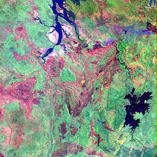 False-color satellite image shows a portion of the Kimberley Plateau, situated north of the Great Sandy Desert in a remote stretch of the province of Western Australia. In this scene, the Durack, Chamberlain, and Ord Rivers wind their way northward to the Joseph Bonaparte Gulf. The long elongated water bodies in the north are backwaters from the Timor Sea. The reddish brown patches are fire scars in the otherwise densely-vegetated (green) area. During the summer months, lightning strikes can quickly spark dozens of wildfires across Australia&apos;s Western and Northern Territories, giving the landscape its mottled appearance. Image courtesy of NASA.