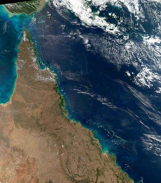 This view of northeast Australia taken by the Aqua satellite vividly shows the many offshore reefs that together form the Great Barrier Reef. The Reef stretches more than 2,000 km (1,240 mi) along the coast of Queensland and is a UNESCO World Heritage Site. Between the reefs and the coastline bands of brown-green &quot;streamers&quot; may be discerned. These are blue-green bacteria (cyanobacteria) that form long overlapping strands and films that can cover immense areas becoming visible even from space. Sailors have long called these brown streamers &quot;sea sawdust.&quot; Image courtesy of NASA.