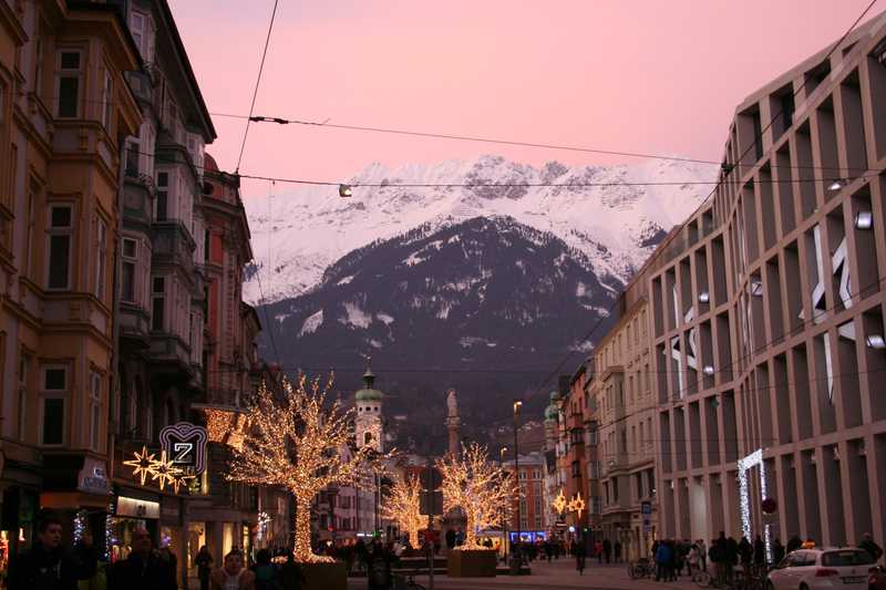 Christmas lights and the night sky glow along the pedestrian mall in Innsbruck during the holiday season.
