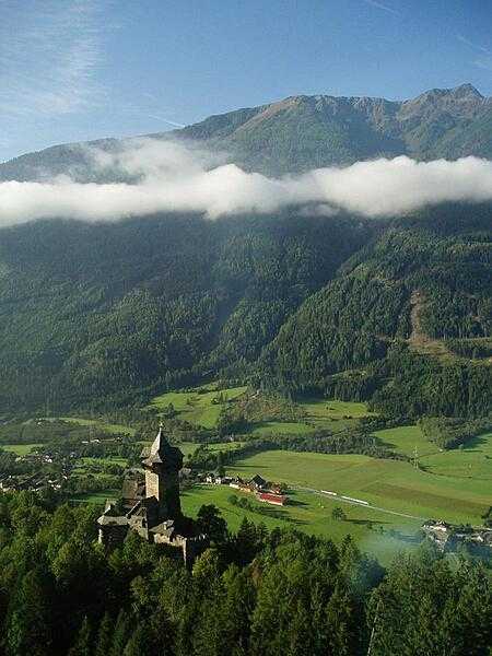 A castle and mountain valley in the Alps.