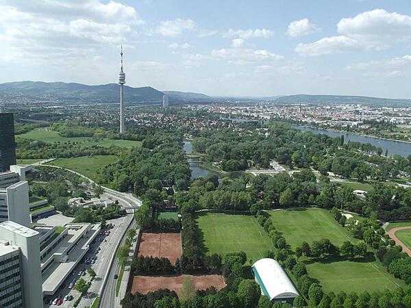 The Donauturm (Danube Tower) overlooks the extensive Danaupark in Vienna. The edges of some of the UN Vienna buildings appear on the left.