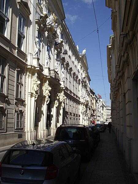 Atlantes and caryatids (male and female supporting sculptures) grace the building facade on a narrow street in Vienna.