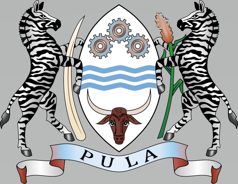 Botswana’s motto, as shown on its coat of arms and its currency, reflects the scarcity of rain in the country: pula means “let there be rain” in Setswana, the national language. The two zebras on the coat of arms are the country’s national symbol. They support an elephant tusk that represents Botswana’s fauna and a head of sorghum that signifies agriculture. The three wavy blue bands symbolize the country’s reliance on water, the cog wheels stand for industry, and the bull’s head represents the cattle industry. The coat of arms also features the national colors of light blue, white, and black.