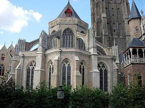The Church of Our Lady in Brugge. Built between the 13th and 15th centuries, it contains both Romanesque and Gothic features; its spire stretches upward for 122 m (401 ft) and remains the tallest structure in the city. The interior contains many important works of art.