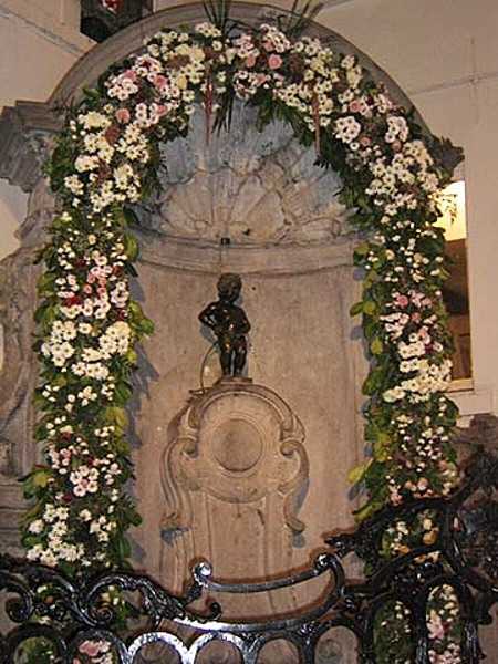 Manneken Pis is a landmark 61 cm (24 in) bronze fountain sculpture in the center of Brussels, depicting a naked little boy urinating into the fountain's basin. Erected in 1618 or 1619, the current statue is a replica that dates from 1965. The original is preserved in the Brussels City Museum. While Manneken Pis is one of the best-known attractions of Brussels, many tourists are taken aback by its small size.
