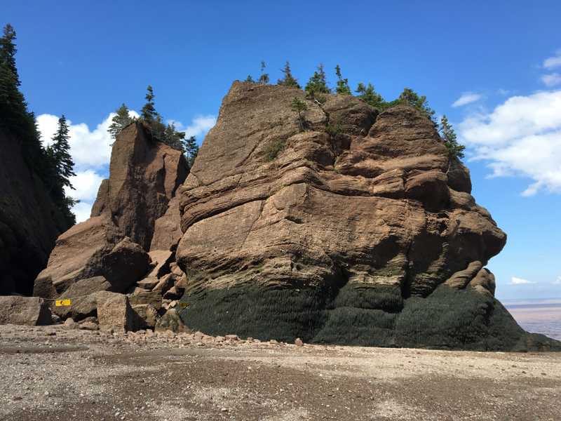 The Bay of Fundy (between New Brunswick and Nova Scotia) is home to the largest recorded tides on Earth, which can seasonally exceed 15 m (50 ft). On the western shore of the bay, Hopewell Rocks are sandstone conglomerates eroded by the rapidly shifting tides. At low tide, the formations are viewable from the beach.