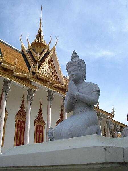 Kneeling figure beside the Silver Pagoda at the Royal Palace grounds in Phnom Penh. The Silver Pagoda lies on the south side of the palace complex. The main building houses many national treasures, including gold and jeweled Buddha statues.