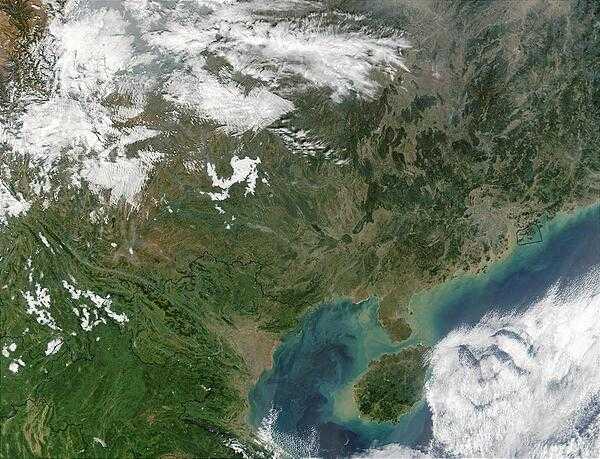 A view of Southern China and the Gulf of Tonkin. Additionally, parts of several Southeast Asian countries may be seen. Thailand appears in the bottom left hand corner, with Burma to the north, and Laos to the northeast. Also visible in this image is Vietnam, which is northeast of Laos, and the expanse of southeastern China dominates the rest of the image. At the center-right of the image, circled in a black outline, is the island of Hong Kong. Hong Kong sits on the South China Sea, which is mostly under cloud cover in this image. West of the South China Sea is the island of Hainan, seen at bottom-center, which separates the sea from the Gulf of Tonkin to the west. In this image, the Gulf of Tonkin is saturated with what seems to be a mixture of sediment and phytoplankton. Photo courtesy of NASA.