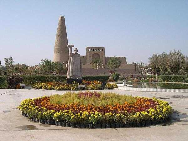 Gardens surround the Emin Mosque and Minaret in Turpan. A statue of Emin Khoja stands before the minaret.