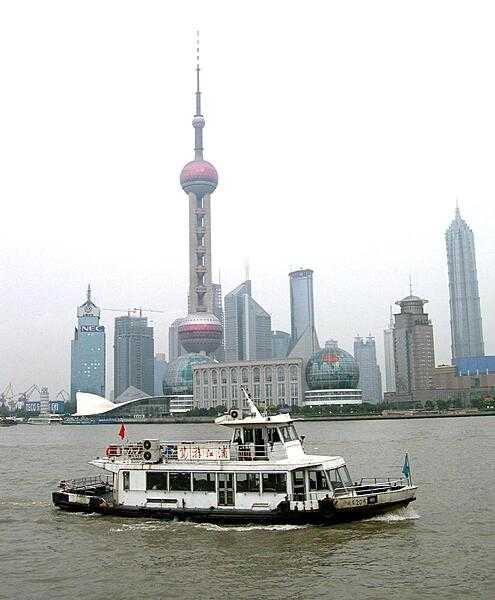 The Oriental Pearl Tower in Shanghai overlooks the Huangpu River. Designed by a local architectural company and completed in 1995, it is 468 m (1,535 ft) tall and has a revolving restaurant, exhibition facilities, restaurants, a shopping mall, and the Space Hotel. The antenna for TV and radio broadcasting adds 118 m (387 ft) to the total height.
