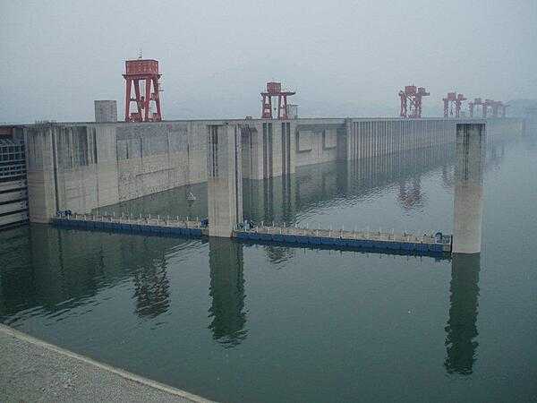 The Three Gorges Dam at Sandouping is the largest hydroelectric power station in the world. It provides power and controls water flow to prevent floods and to supply water downstream during times of drought. Its construction forced the relocation of 1.3 million people and the flooding of thousands of cities, towns, and historical sites. This is a view of the reservoir behind the dam.