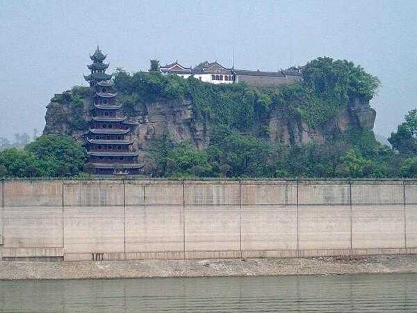 Shibaozhai is a steep, rocky, and craggy hill on the bank of the Yangtze River, in Zhong county, Chongqing. A temple at the crest of the 220 m (722 ft) hill was built in the 18th century. A nine-story wooden pagoda was constructed in the 1819 to aid pilgrims in getting to the top of the hill. In 1956, three more stories were added.  A coffer dam protects the site from higher river waters - the result of the Three Gorges Dam.