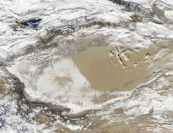 Snow-covered deserts are rare, but that is exactly what NASA&apos;s Aqua satellite observed as it passed over the Takla Makan Desert in the Xinjian Uygyr autonomous region of western China on 2 January 2013. The Takla Makan is one of the world&apos;s largest and hottest sandy deserts. Water flowing into the Tarim Basin has no outlet so, over the years, sediments have steadily accumulated. In parts of the desert, sand can pile up to 300 m (roughly 1,000 ft) high. The mountains that enclose the sea of sand - the Tien Shan in the north and the Kunlun Shan in the south - are also covered with what appears to be a significantly thicker layer of snow. Image courtesy of NASA.