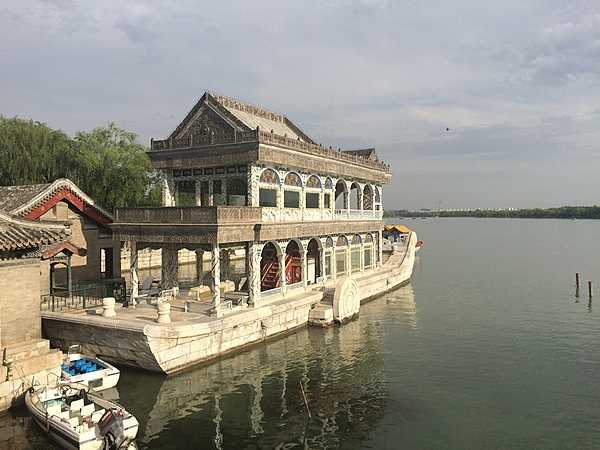 The Summer Palace is a vast ensemble of lakes, gardens, and palaces in Beijing. It was an imperial garden in the Qing dynasty (1644 to 1912). UNESCO added the Summer Palace to its World Heritage List in 1998. The Stone Boat, a lakeside pavilion on the grounds of the Summer Palace in Beijing, is 36 m long; it replaces an original wooden boat that burnt in1860. The new structure is also wooden and sits on a base of large stone blocks. The wood is painted to imitate marble and displays an imitation western-style paddle wheel on both sides.