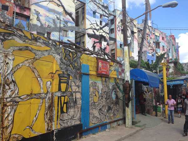 Street side and apartment wall murals help brighten a run down section of Havana.