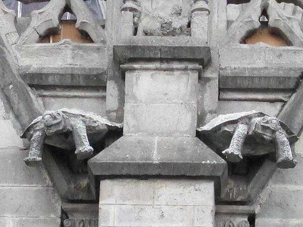 A close-up of two turtle-shaped gargoyles on the side of the Basilica of the National Vow in Quito.