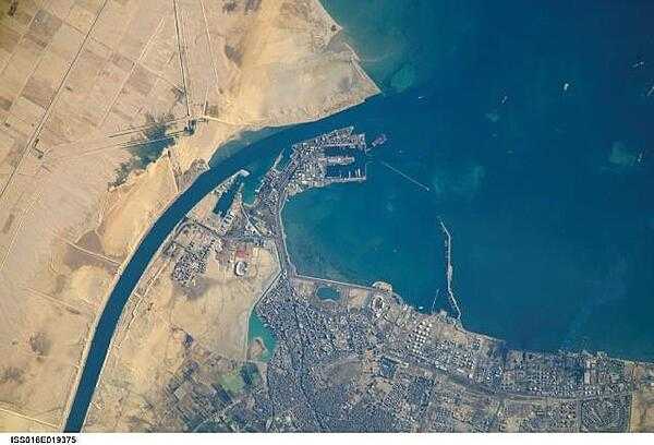 The Port of Suez - here viewed from the International Space Station - is located in Egypt along the northern coastline of the Gulf of Suez. The port and city are the southern terminus of the Suez Canal that transits through Egypt and debouches into the Mediterranean Sea near Port Said. The port serves vessels transporting general cargo, oil tankers, and both commercial and private passenger vessels. Several large vessels are visible in the Gulf of Suez and berthed at various docks around the port. Photo courtesy of NASA.