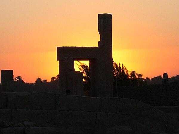 A vivid sunset behind some of the ruins at Kom Ombo.