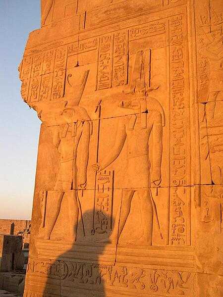 Inscriptions on a wall at Kom Ombo showing the crocodile god Sobek and the falcon god Horus.