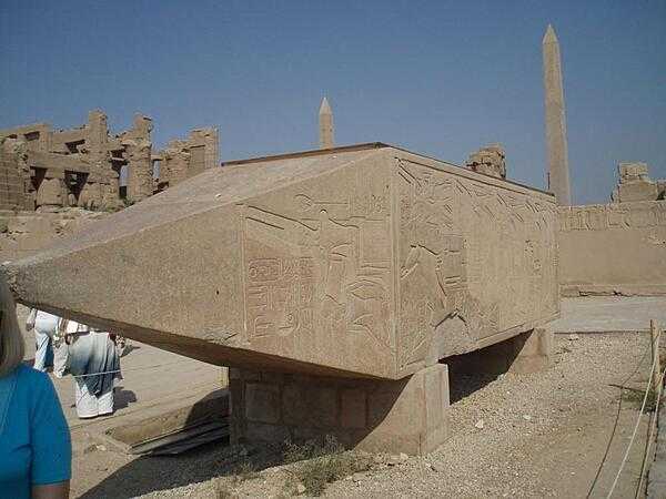 The remains of an obelisk not erected because of cracking. The obelisks of Hatshepsut and Thutmose I appear in the background at the Temple of Karnak in Luxor.
