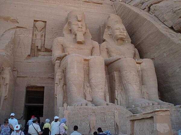 Right pylon of the Temple or Ramses II at Abu Simbel. The figures at the base of the colossi are the mother, wife and children of Ramses II. The figure above the entrance is the god, Ra-Harakhte (Ra and Horus).