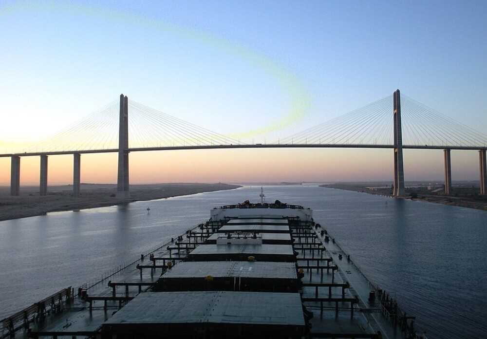 The Suez Canal was opened on November 17, 1869. The Canal connects Port Said on the Mediterranean Sea with the port of Suez on the Red Sea, providing a direct route for transporting goods between Europe and Asia. The Canal is 163 km (101 mi) long and 300 m (984 ft) wide at its narrowest point – which is wide enough for ships as large as aircraft carriers. The bridge pictured is the Suez Canal Bridge (also known as the Egyptian-Japanese Friendship Bridge or the Peace Bridge), which opened in 2001 and connects the continents of Africa and Asia.