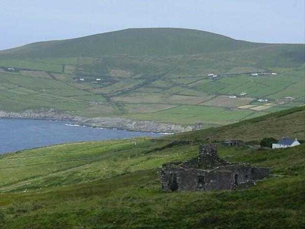 The ruins of an old farm house front a vista of patchwork Irish countryside.