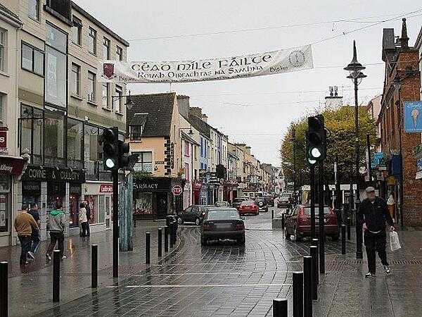 Street view of Killarney, County Kerry. Killarney is one of the principal towns in the country and a center of tourism for the region. The sign over the street reads &quot;A Hundred Thousand Welcomes&quot; (Cead Mille Failte).
