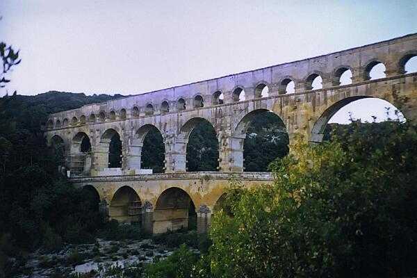 The Roman aqueduct at Pont du Gard, built during the mid-first century A.D., was part of a 50 km (30 mi) long aqueduct system that brought water to the city of Nemausus (today&apos;s Nimes). Built entirely without the use of mortar, its construction is thought to have taken about three years using 800 to 1,000 workers.