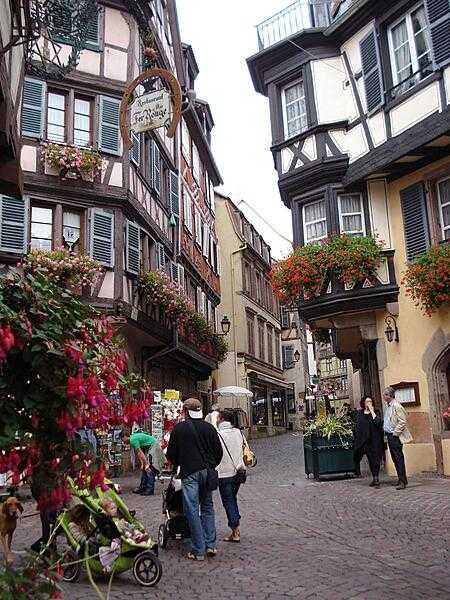 Half timbered houses along a shopping street in old Colmar.