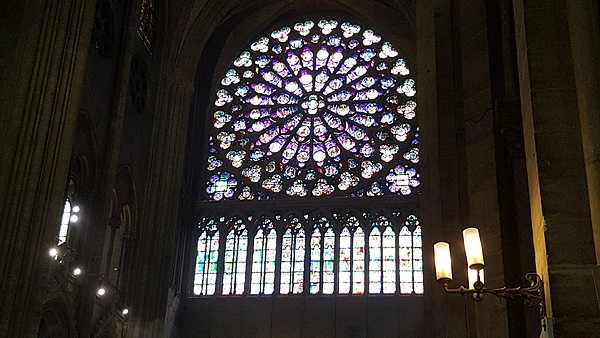 The South Rose Window in Notre Dame Cathedral was a gift from the French king Saint Louis IX in 1260. The stained glass window measures 12.9 m (42 ft) in diameter and contains 84 panes of glass. The themes are the New Testament and the Triumph of Christ reigning over heaven and surrounded by all his witnesses on earth.