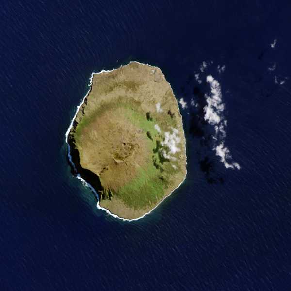 The Landsat 8 satellite acquired this close-up view of Amsterdam Island on 26 March 2015. This volcanic summit sits near the East Indian Ocean Ridge, and it is the northernmost volcano above the water line on the Antarctic plate. The highest point of the island stands 867 m (2,844 ft) above sea level. There are two calderas within an area of just 70 sq km. Some scientists suggest that the volcano was last active about 200,000 to 400,000 years ago, but there are hints that an eruption may have occurred more recently. This is the most remote active volcano on the planet. Amsterdam Island is staggeringly far from anything.
•	4,300 km (2,670 mi) from Africa
•	3,400 km (2,100 mi) from Madagascar
•	5,000 km (3,100 mi) from Sri Lanka
•	3,450 km (2,140 mi) from Australia
•	3,200 km (1,990 mi) from Antarctica. Photo courtesy of NASA.