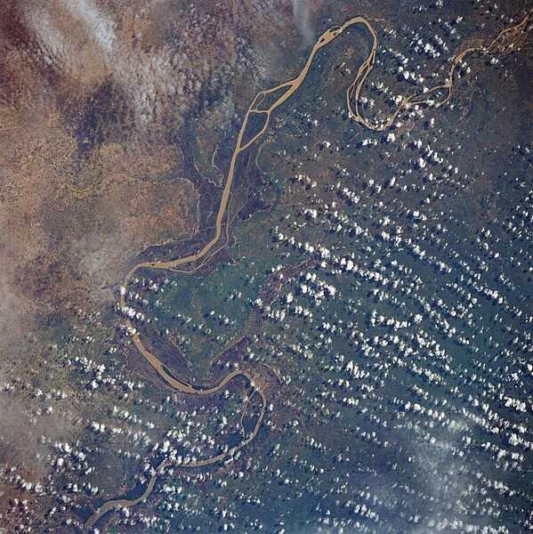 The Gambia River, from Georgetown in the upper right corner of the photograph downstream to Mansa Konko, where it becomes an estuary about 100 km (60 mi) above Banjul, the capital of The Gambia. The river is heavily silted from rain originating in the highlands of Guinea. Image courtesy of NASA.