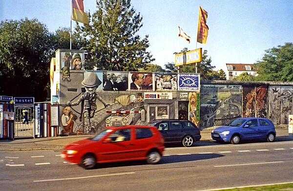 A preserved portion of the Berlin Wall. The wall was begun in 1961 and completely encircled West Berlin. The beginning of the end of the wall came in 1989 when the East German regime allowed East Berliners to visit West Berlin. The former wall is marked in some places by cobblestones.