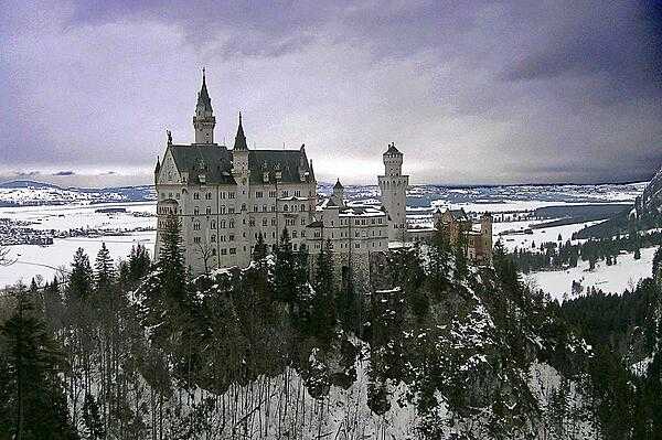 Winter view of Neuschwanstein Castle as seen from the Marienbruecke (Mary&apos;s Bridge).  This castle is the best known of the three royal palaces built by King Ludwig II of Bavaria. The design and decoration of the castle pay homage to various medieval legends.