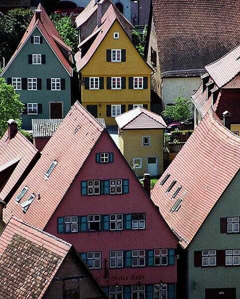 A view of the colorful houses in Dinklesbuehl captured from a church tower. The city is surrounded by medieval walls and towers.