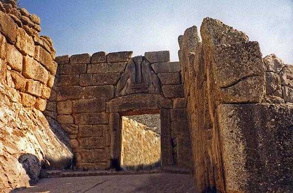 The Lion Gate at the Late Bronze Age site of Mycenae. The archeological site is located 90 km (55 mi) southwest of Athens on the Peloponnesian Peninsula. Agamemnon, Clytemnestra, and Orestes all reputedly lived in the royal palace of the fortified city.