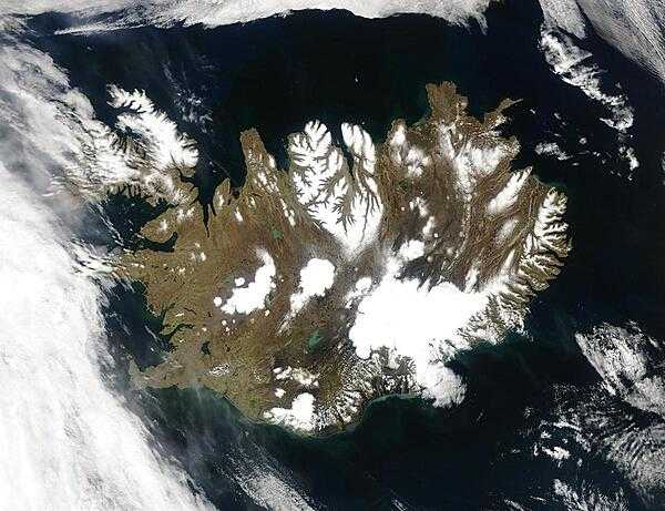 Summer temperatures melt snow and ice on much of Iceland&apos;s surface, as shown on this satellite image. The lack of uniform snow cover allows permanent (though shrinking) icefields to show through (particularly Vatnajokull in the southeast), and highlights the island&apos;s rugged coastline. Scores of fjords edge the island, resembling feathers waving out into the waters of the northern Atlantic Ocean (bottom) and Greenland Sea (upper left). 
Though Iceland&apos;s climate is relatively mild and humid thanks to the North Atlantic Drift, and though the island&apos;s active volcanism provides inexpensive heating, only about the a quarter of the island is habitable, most of that along the coastlines. Photo courtesy of NASA.