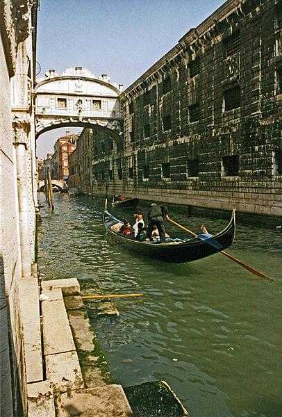 Gondola on a Venetian canal approaching the Bridge of Sighs.