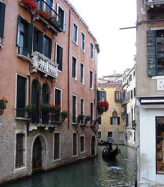 A gondola winds its way through a Venice canal.