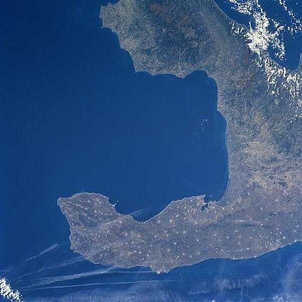 The Salentino Peninsula (bottom of image), also known as &quot;the heel of Italy,&quot; is the elongated promontory that juts southeasterly from the larger Italian Peninsula. This peninsula is bordered by the Adriatic Sea to the northeast (bottom of image) and the Gulf of Taranto to the southwest (center of image). The peninsula consists of gently rolling hills and coastal plains, thereby promoting an agrarian economy. The numerous, light-colored spots seen throughout the peninsula show the location of small agricultural towns and villages. Photo courtesy of NASA.