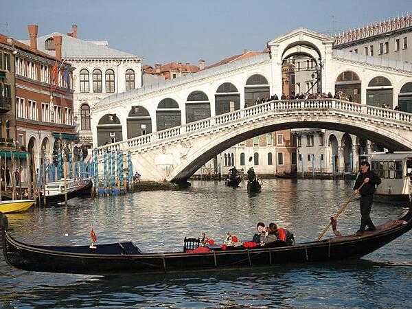 The Rialto Bridge was one of the first bridges to span the Grand Canal in Venice allowing residents to access the Rialto Market. The structure was originally constructed of wood, but after it collapsed twice under the weight of residents watching boat races, it was replaced by a stone bridge in 1591.