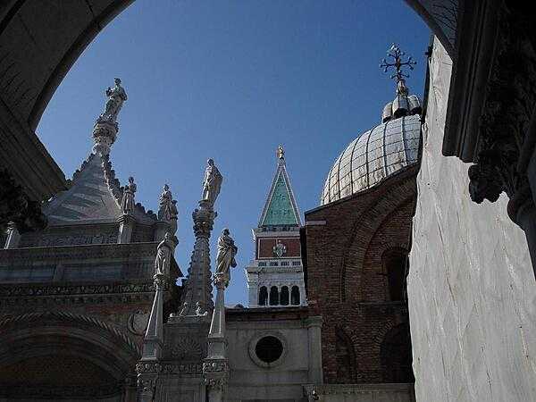 A view of the Cathedral of St. Mark&apos;s in Venice showing some of the saints adorning its roof, and a peek at its bell tower.