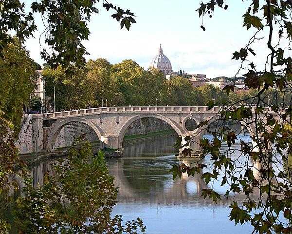 The Garibaldi Bridge over the Tiber River in Rome. The dome of St. Peter&apos;s Basilica appears in the background.