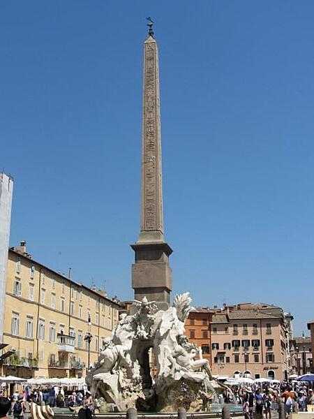 The obelisk presently in the Plaza Navona in Rome was created in Aswan, Egypt at the request of Emperor Domitian in the 1st century A.D. At one time it stood in the Circus Maximus. The obelisk is surrounded by the Fountain of Four Rivers (Fontana dei Quattro Fiumi) built by Gian Lorenzo Bernini in 1651. The fountain shows four river gods representing four continents under papal authority. The gods stand for the Nile, Danube, Ganges, and Platte.