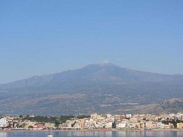 The city of Naxos in Sicily lies at the foot of Mount Etna. The resort city of Taormina is 7 km (4.5 mi) in the distance.